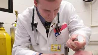 A medical student practices on a dummy