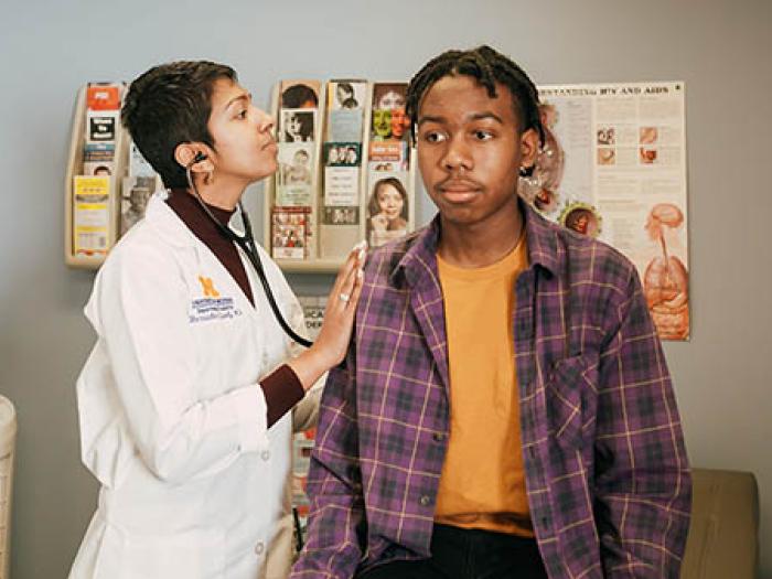 Female doctor with stethoscope and young Black male