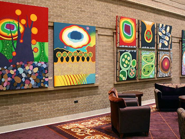 Collection of brightly colored, modern paintings on a hospital corridor wall