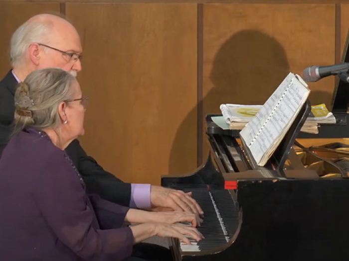 elderly man and woman playing the piano