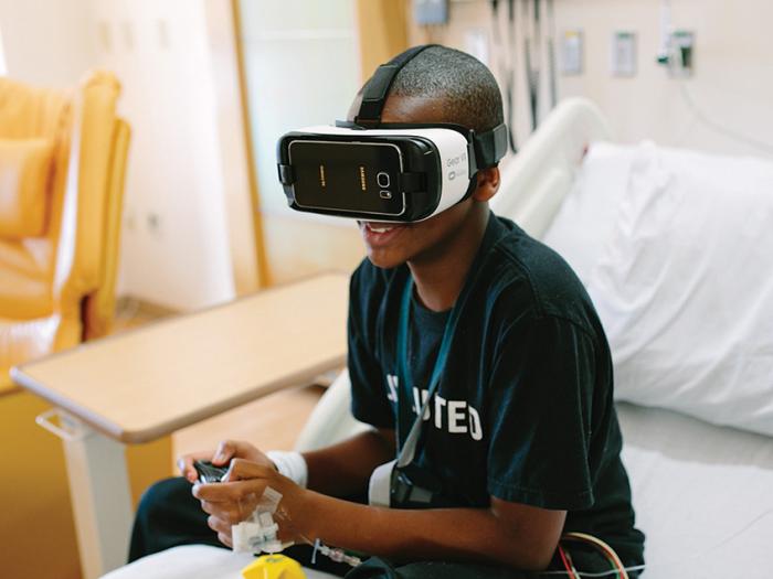 boy patient playing vr game in hospital bed