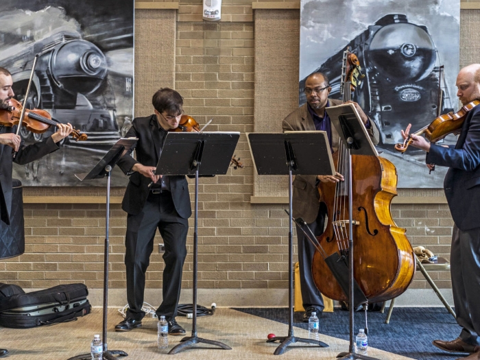 Violinists and a cellist perform a concert