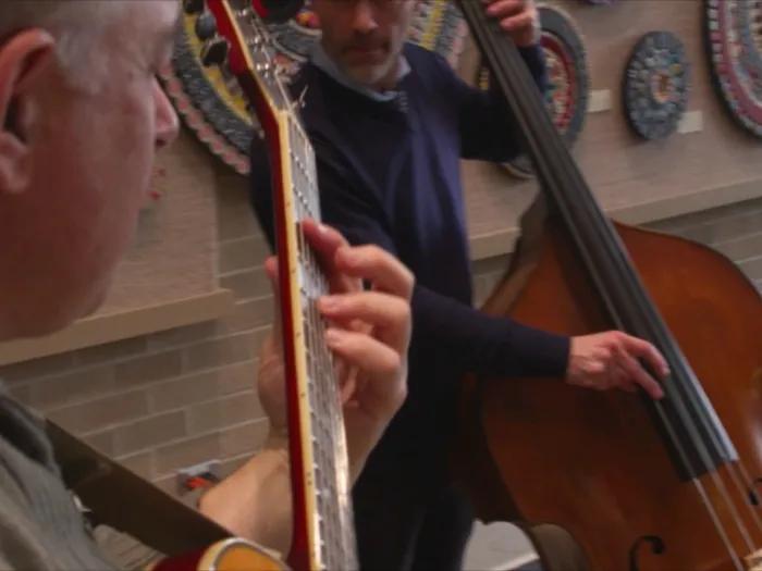 guitarists perform in front of the art display