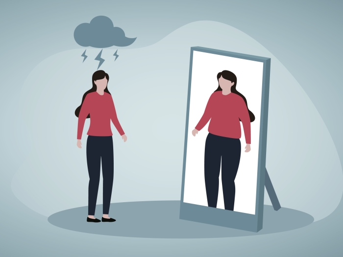 Women in red shirt with cloud hanging over her head looking in mirror