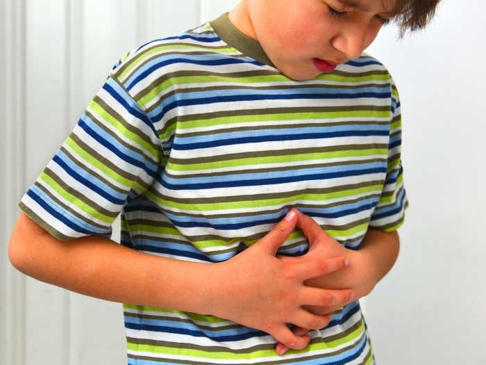 kid holding stomach with stripped shirt green blue white