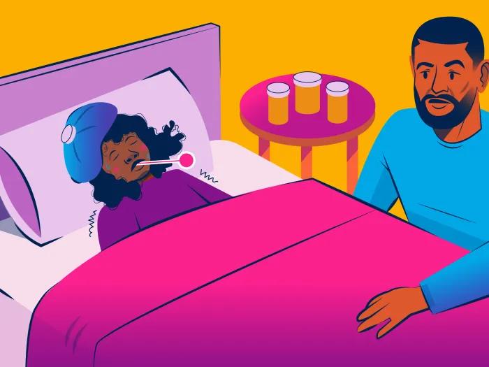 parent at bedside with sick kid in bed with head cooler and thermometer 