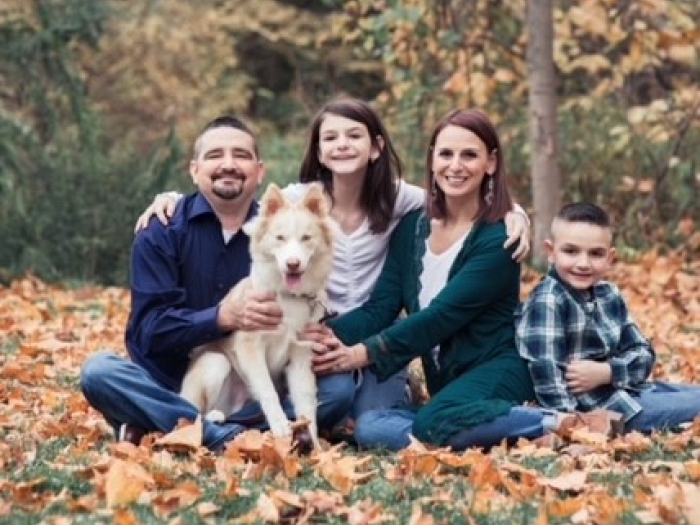 Danny poses for a photo with his family and dog