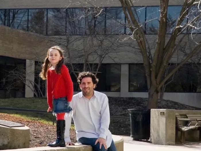 Emma and her dad pose for a photo outside