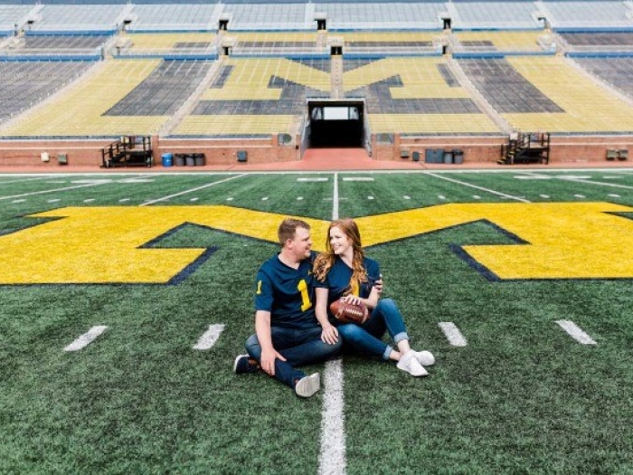 Tucker smiles on the Michigan football field with his wife