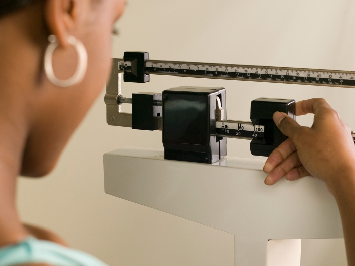 Woman weighing herself and a scale measurement