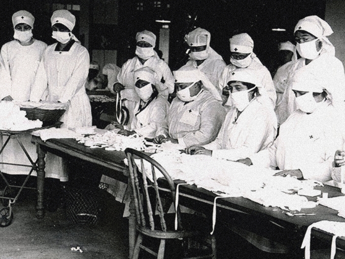 nurses from 1918 wearing masks in hospitals standing together black and white photo