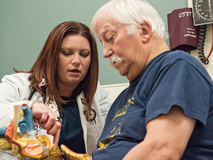 Nurse educating a patient who is holding a heart model