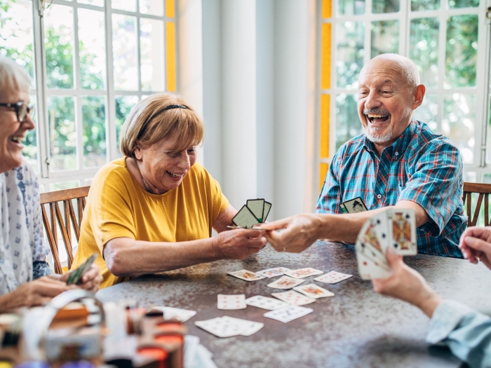 older adults playing cards at table