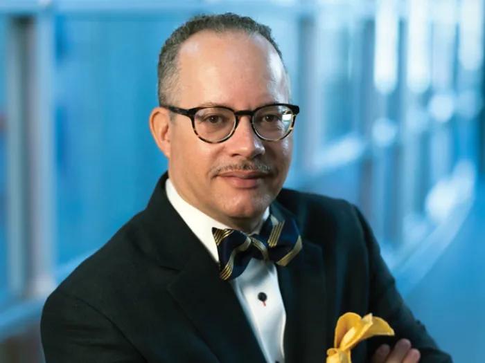 headshot of henry bell. he has glasses and is wearing a tuxedo with a gold and blue bowtie.