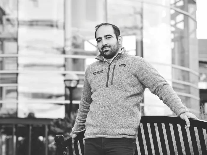 black and white photo of mustafa saadi standing in front of a building