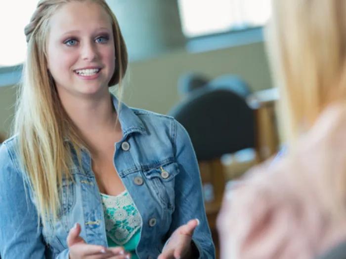 Teen girl speaks with a woman