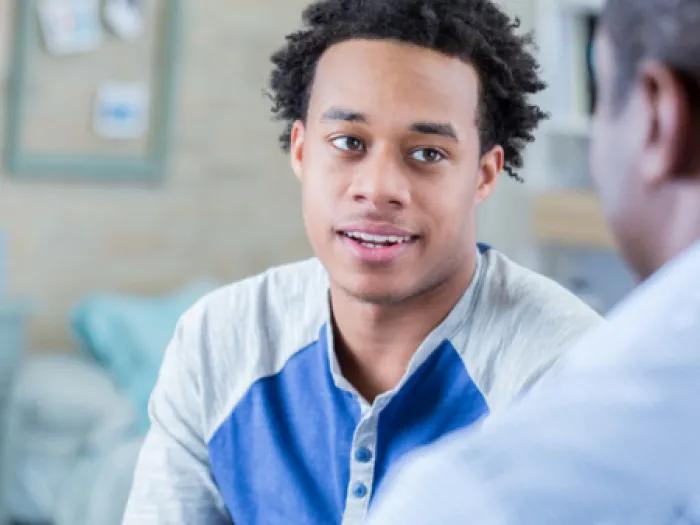 Teen boy speaks with staff