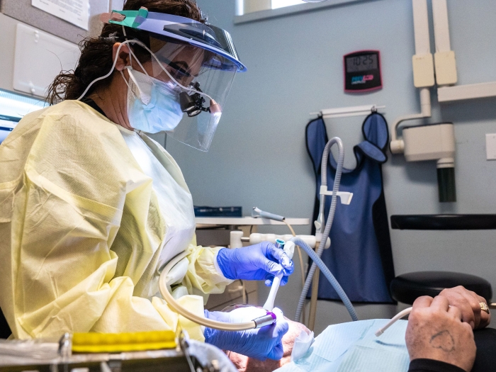 A dentist operates on a patient at Exalta Health in Grand Rapids