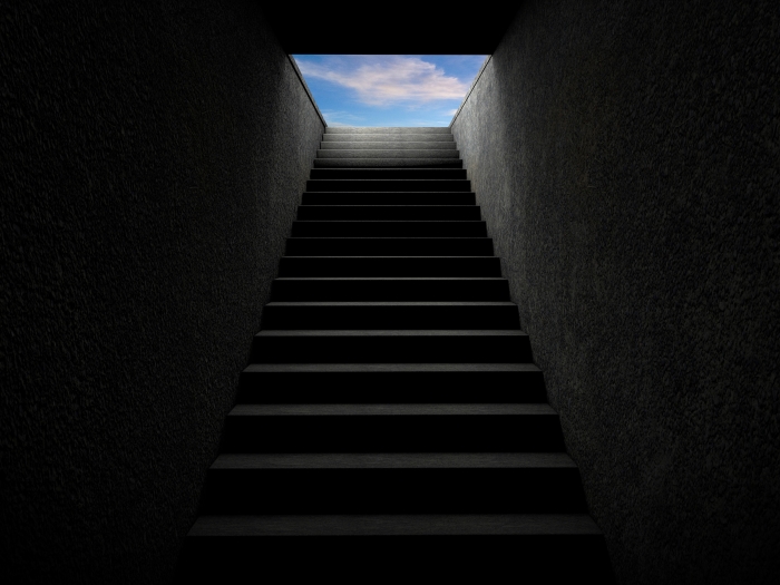 Dark staircase leading to blue sky above