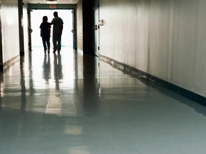 Photo of two silhouettes in a hallway 