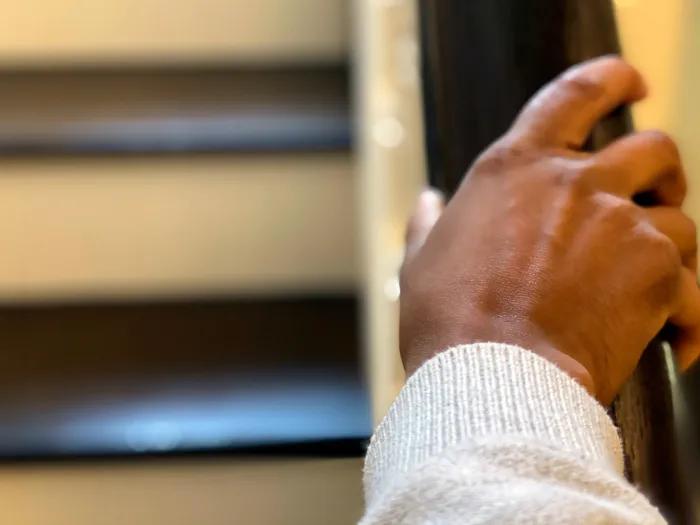 Photo of hand gripping the bannister on a stairway