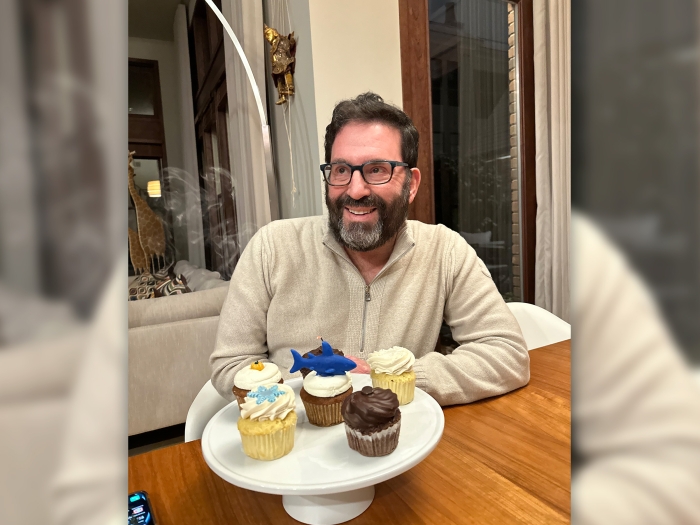 man smiling with cupcakes glasses