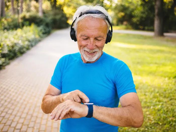 man outside blue shirt headphones watch