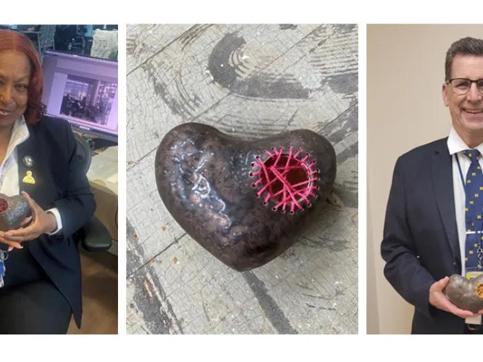 Two staff members hold their Unsung Heroes award, plus a close-up shot of the Unsung Heroes award. It is a dark clay heart with pink stitching across a hole in it.
