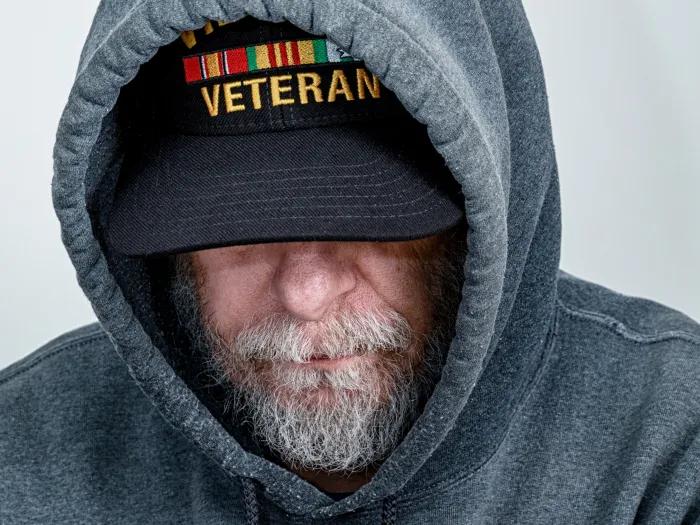 man in veteran hat with hooded sweatshirt