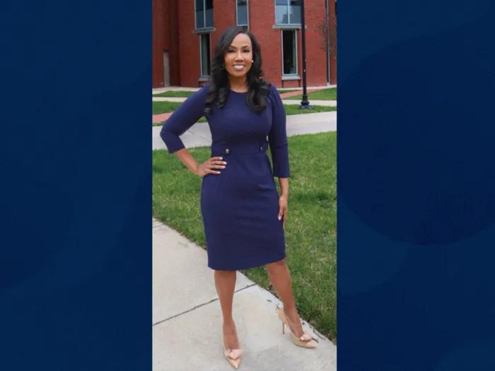 woman dressed up in blue navy dress with hand on hip