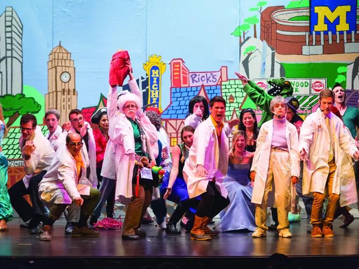 Students on stage in costume perform a song during the 2015 Galens Smoker spoof show.