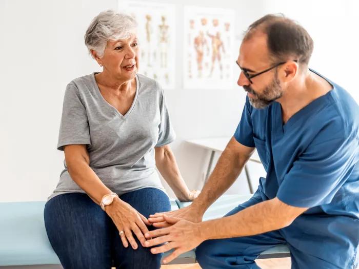 woman on table with doctor talking to her