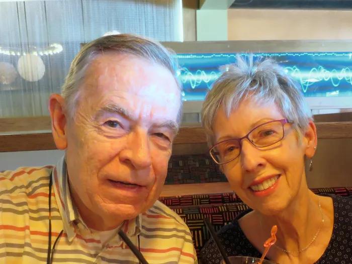 Headshot Bert and Pat Armstrong smiling and seated in a booth on their cruise in Bermuda. 