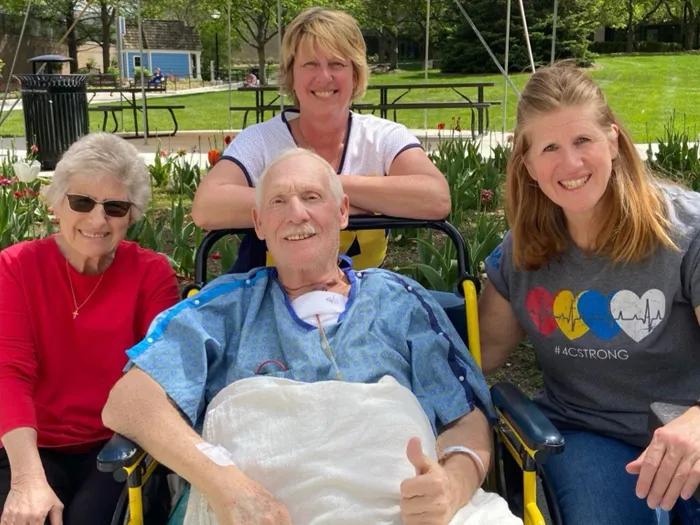 family with father patient at hospital outside in wheelchair
