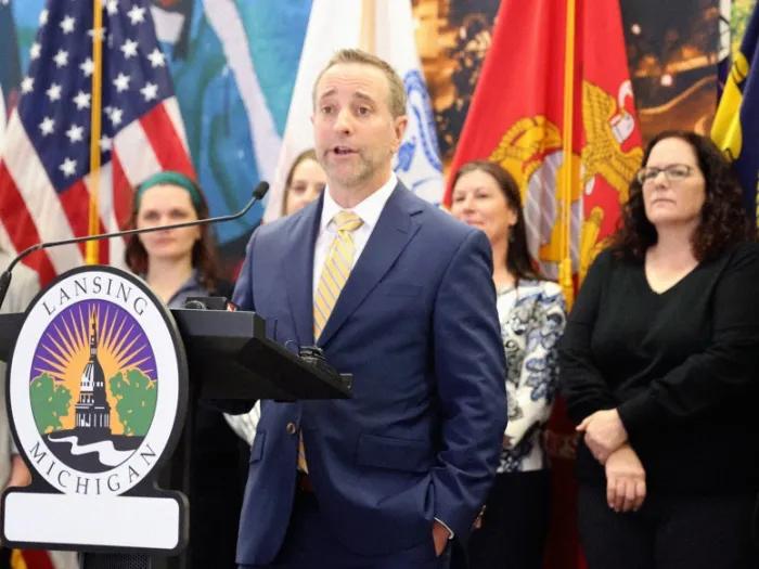 man speaking at podium in Lansing, Michigan 