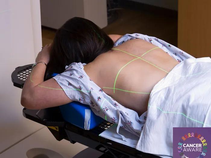 Woman lays on stomach preparing for radiation of the spine