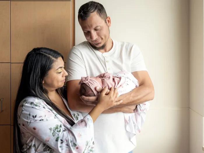 parents holding baby in hospital