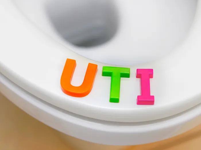 UTI written out with block letters on a toilet seat white