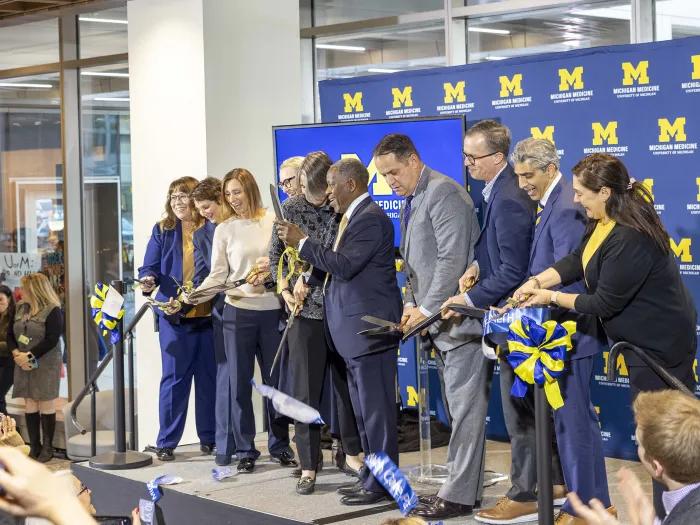 Ribbon cutting at the opening of the Kahn Pavillion. Ten Michigan leaders cut the blue ribbon
