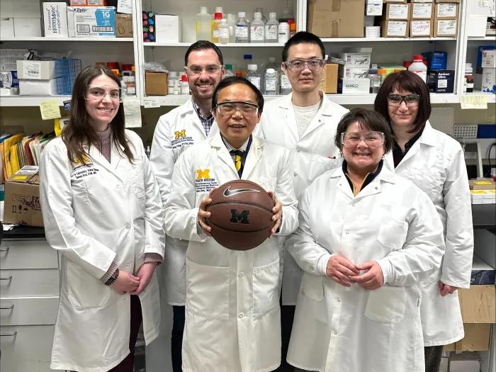 Members of Eugene Chen's laboratory with a basketball