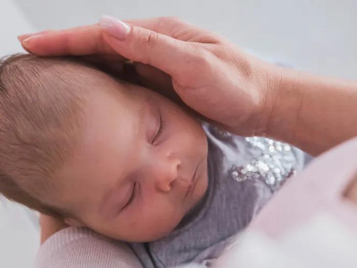 newborn close up in adult's arms