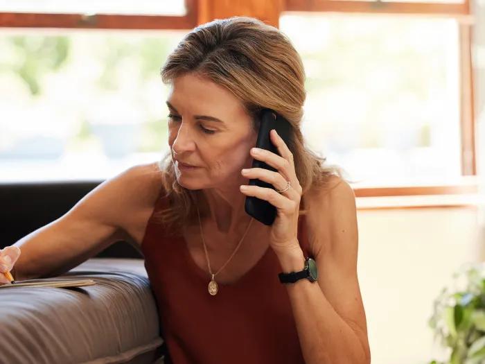 woman on phone taking notes