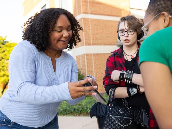A group of youth looking at a cell phone.
