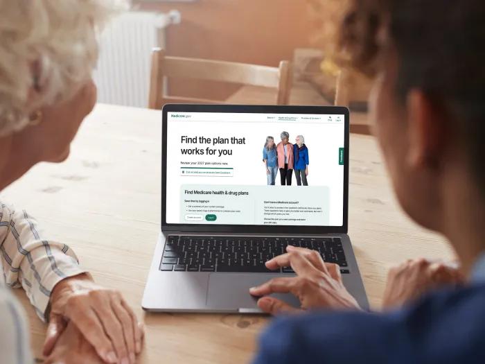Two older women looking at the Medicare website on a laptop screen