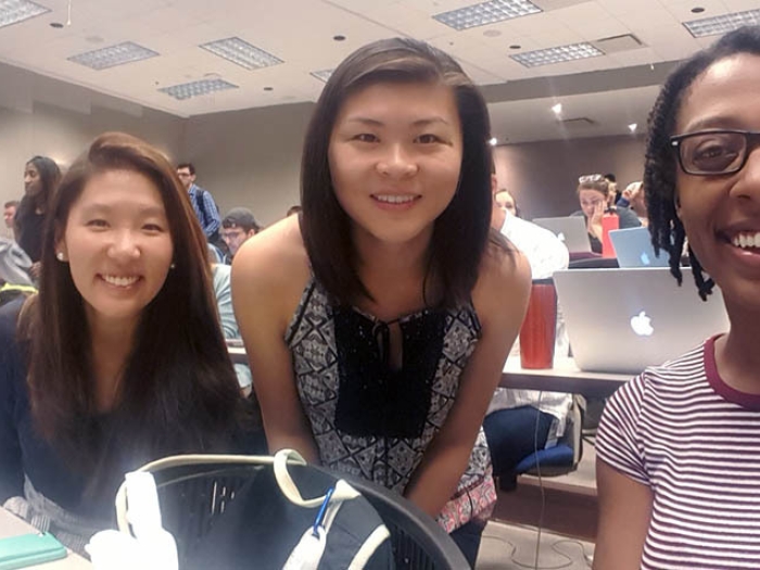 three girls looking at camera smiling in room
