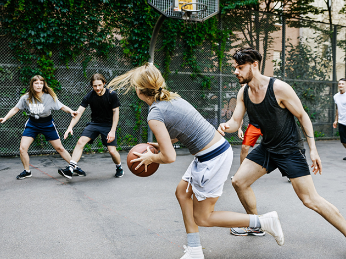 Men and women playing basketball