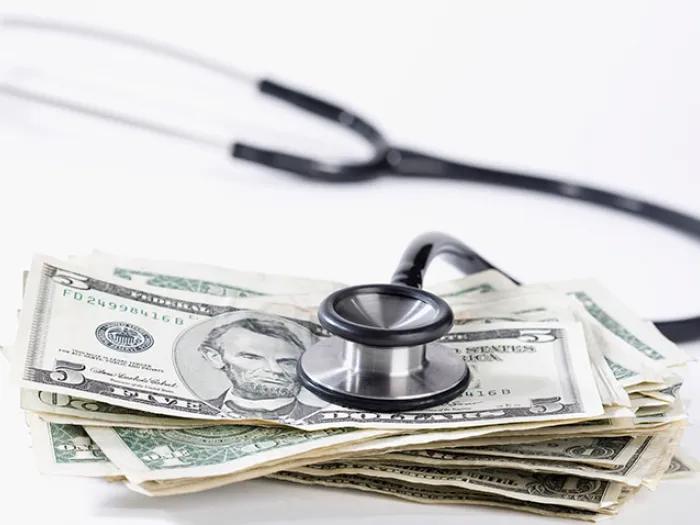 Stethoscope resting on a pile of money