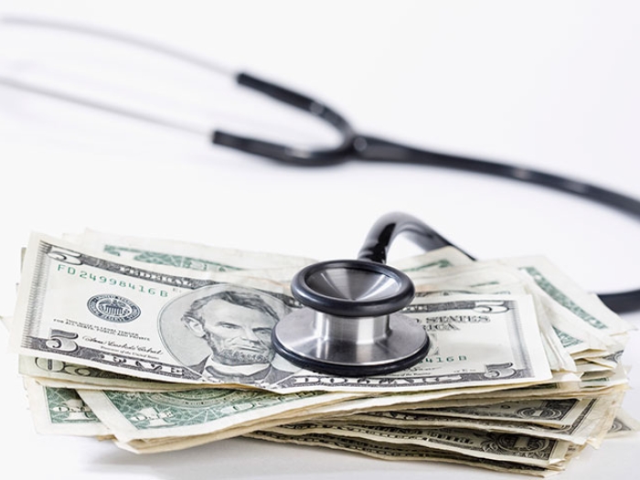 Stethoscope resting on a pile of money