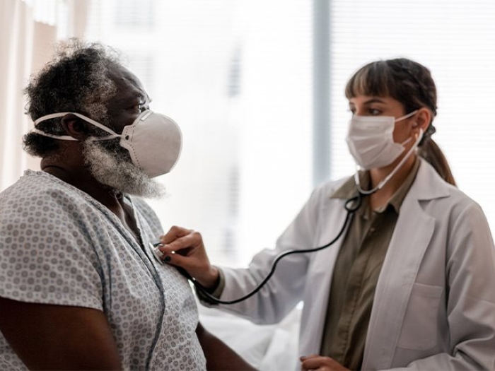 black man getting checked by doctor with masks on 