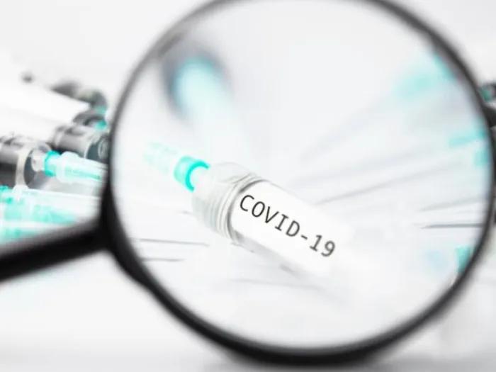 magnifying glass on COVID vaccine Needles